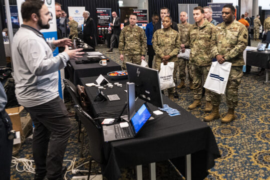 Brig. Gen. Otis C. Jones, 86th Airlift Wing commander, and 86th AW leadership, listen to a technology explanation at a technology exposition at Ramstein Air Base, Germany, Feb. 7, 2023. The tech expo is a way to expose the RAB community  to innovative solutions and technologies and learn from private sectors. (U.S. Air Force photo by Senior Airman Thomas Karol)