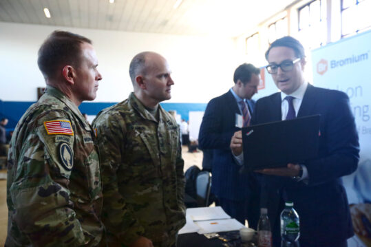 U.S. Army Col. Jeff Worthington, commander of 2nd Theater Signal Brigade, and Col. Rob Parker, the U.S. Army Europe chief information officer/G-6, speak with an exhibitor during the U.S. Army Garrison Wiesbaden Tech Expo, Feb. 13, 2018 in the Tony Bass Gym on Clay Kaserne in Wiesbaden, Germany. (U.S. Army photo by William B. King)